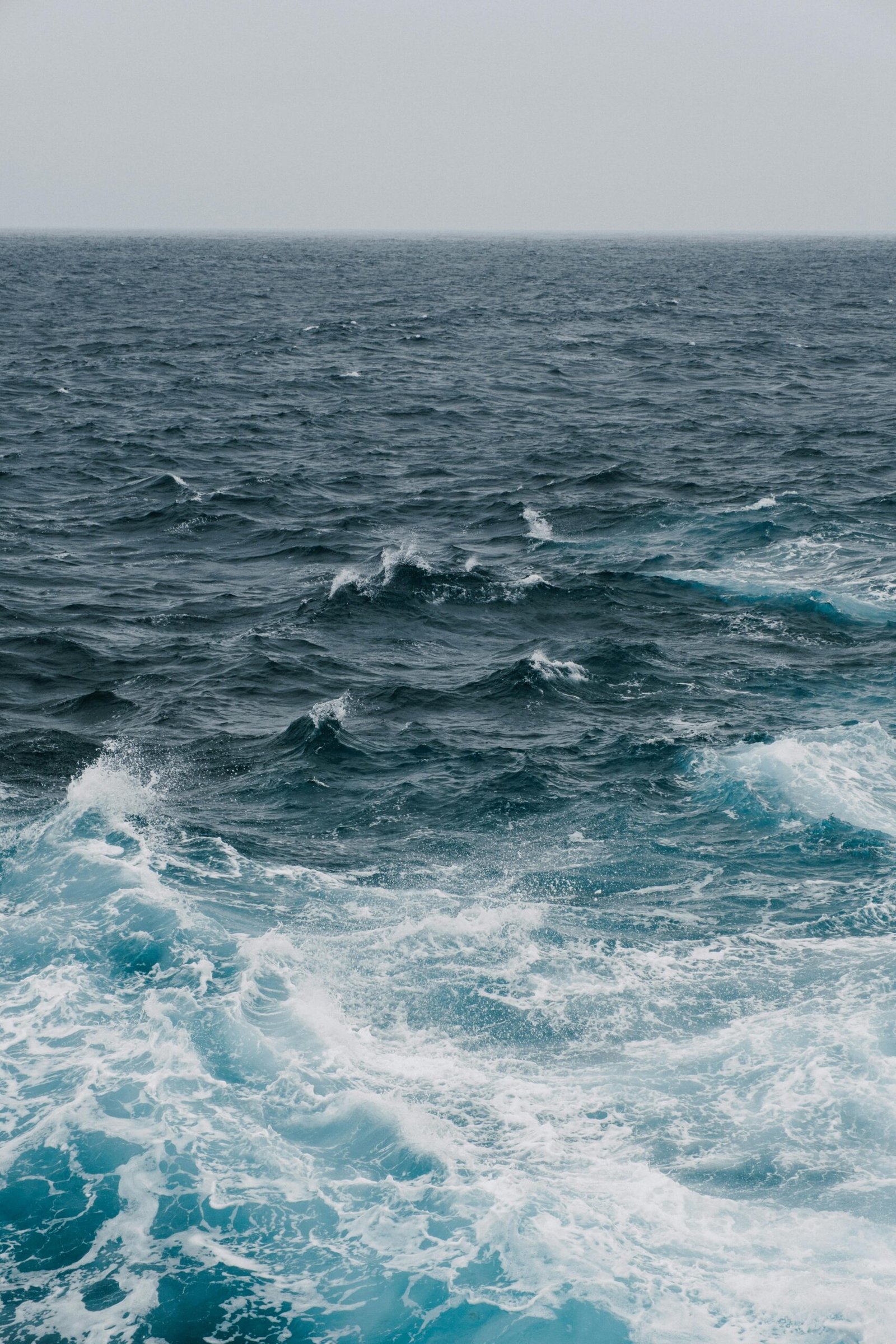 Experience the raw power of the ocean as waves crash under a cloudy sky, showcasing nature's dynamic beauty.